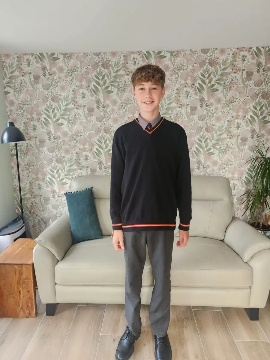 Estudiante con uniforme escolar preparado para ir a clase