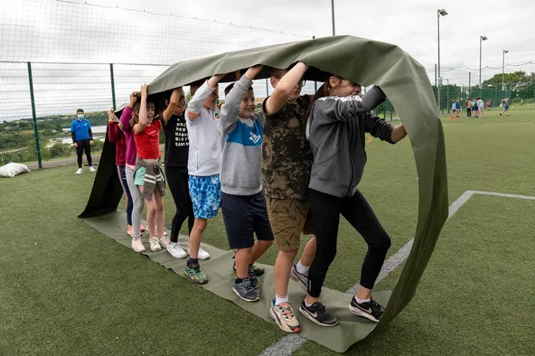 Niños participando en una actividad de equipo en un campamento de día en Irlanda