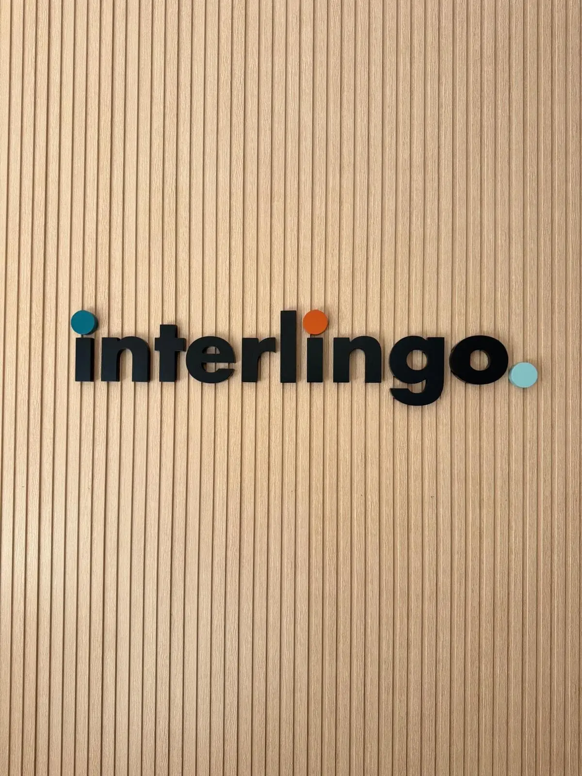 Logotipo de Interlingo en la pared de madera del interior de la oficina